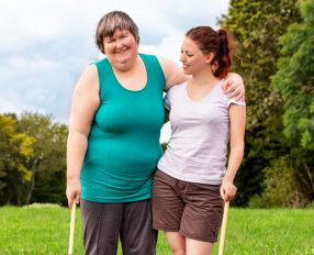 a caregiver and a woman with disability smiling